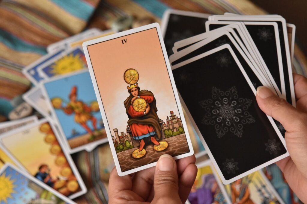 A close-up image of a person holding and displaying a tarot card during a reading session.
